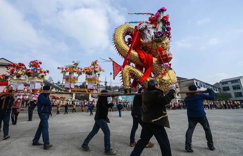 2月11日,浦江縣白馬鎮(zhèn)旌塢村百姓抬著板凳龍?jiān)趶V場上舞動。 新華社記者 徐昱 攝