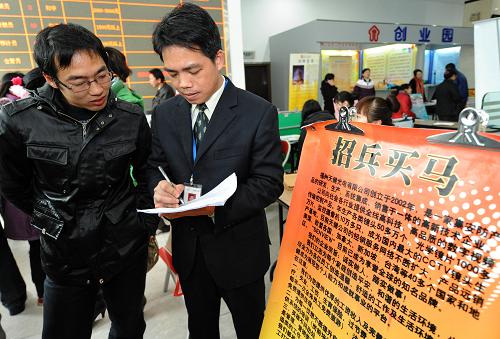 2月14日,一家企業(yè)招聘人員(右)在福州勞動保障大廈舉行的用工招聘會上向求職者介紹用工信息。