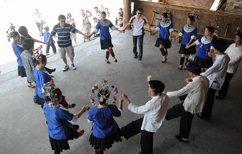 5月19日,游客在廣西三江侗族自治縣程陽八寨參與民族風(fēng)情表演“多耶”活動。當(dāng)日,廣西三江侗族自治縣所有景區(qū)都以半票或者免票接待游客。新華社發(fā)(梁克川 攝)