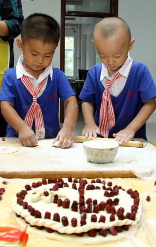 9月7日,濰坊北海幼兒園的孩子們在老師與家長的幫助下做“月”。新華社發(fā)(孫樹寶 攝)