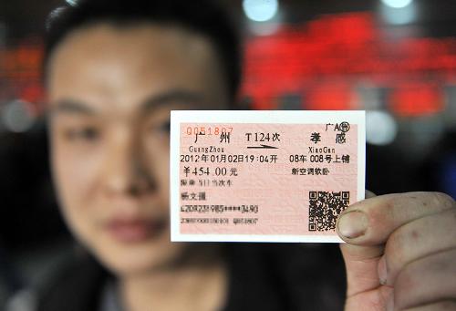 1月1日,一位旅客在廣州火車站售票廳展示剛買到的實名制火車票(旅客個人信息已做馬賽克處理)。新華社記者 陳曄華 攝