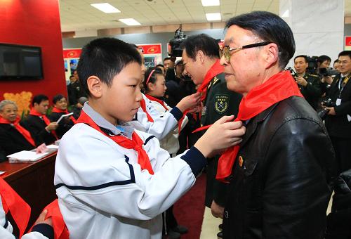 3月2日,在開幕式上少先隊員為雷鋒班第一任班長張興吉(右)佩戴紅領(lǐng)巾。新華社記者 查春明 攝