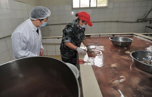 3月14日,湖南省質監(jiān)部門的執(zhí)法人員在一家食品企業(yè)檢查產品生產流程。新華社記者 李尕 攝