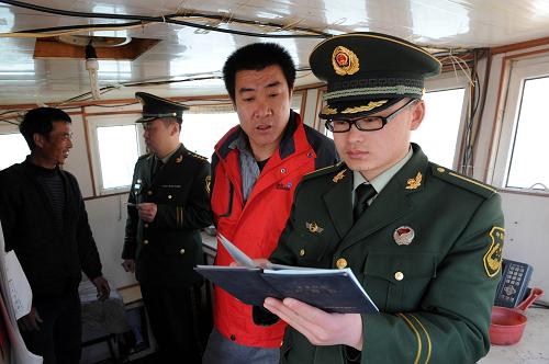 3月14日,青島沙子口邊防派出所民警對即將出海的漁船進(jìn)行證照檢查、核對。 新華社記者 李紫恒 攝