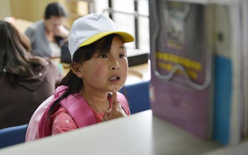 5月8日,一名學(xué)生在陜西省圖書館少兒閱覽室挑選圖書。新華社記者 劉瀟 攝