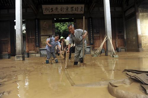 7月1日,群眾在安徽省黃山市徽州區(qū)受損嚴(yán)重的羅東舒祠前清淤。新華社發(fā)(馬啟兵 攝)