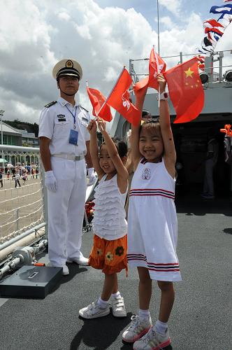 7月1日,兩名兒童在新型護(hù)衛(wèi)艦“惠州”艦上揮舞國旗和區(qū)旗。新華社記者 黃本強(qiáng) 攝