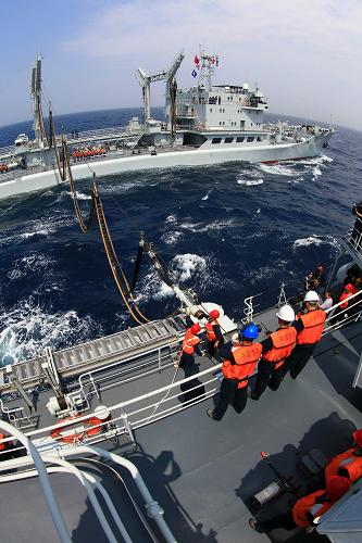 7月4日,綜合補(bǔ)給艦洪澤湖艦補(bǔ)給裝置伸向沈陽(yáng)艦。新華社記者 查春明 攝