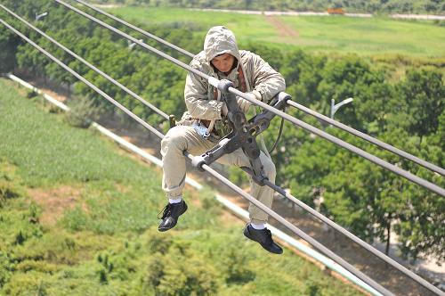 8月7日,在南京市江寧區(qū)一處500千伏輸電塔,32歲的電力工人羅大江在對(duì)間隔棒進(jìn)行維護(hù)。新華社發(fā) (李響 攝)