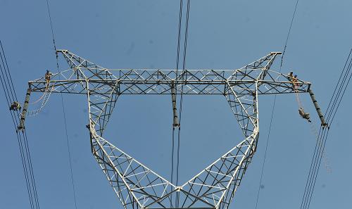 8月7日,在南京市江寧區(qū)一處500千伏輸電塔,電力工人在塔頂放下絕緣梯,準(zhǔn)備登上高壓線(xiàn)。新華社發(fā) (李響 攝)
