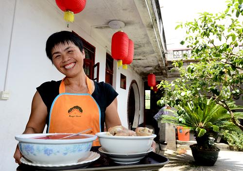 8月7日,古田鎮(zhèn)上羊村婦女付梅蘭在農(nóng)家樂(lè)飯莊為游客送菜。紅色圣地——福建省上杭縣古田鎮(zhèn),是著名的“古田會(huì)議”舊址所在地,也是中國(guó)歷史文化名鎮(zhèn)。近年來(lái),古田鎮(zhèn)以紅色旅游為依托,因地制宜發(fā)展生態(tài)觀光農(nóng)業(yè)、生態(tài)鄉(xiāng)村旅游業(yè),家庭旅館、農(nóng)家樂(lè)等特色產(chǎn)業(yè)蓬勃興起,農(nóng)民收入逐年增加。2013年1-6月,全鎮(zhèn)財(cái)政總收入1586萬(wàn)元,同比增長(zhǎng)12%;農(nóng)民人均純收入4978元,同比增長(zhǎng)11.2%。新華社記者 張國(guó)俊 攝