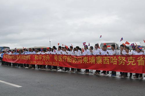 9月24日,在柬埔寨西哈努克港,當(dāng)?shù)貙W(xué)生揮舞中柬兩國(guó)國(guó)旗歡迎中國(guó)海軍和平方舟醫(yī)院船。新華社記者 李弘 攝