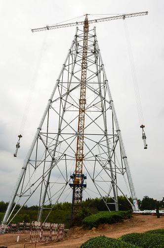 9月26日,施工人員在用吊車吊裝鐵塔組件。當(dāng)日,1000千伏浙北-福州特高壓交流輸變電工程在浙江省金華市武義縣啟動(dòng)了首個(gè)鐵塔組立試點(diǎn)工程,這標(biāo)志著該工程進(jìn)入了全線的鐵塔組立施工階段,為確保2014年底前實(shí)現(xiàn)全線架通奠定了基礎(chǔ)。浙北-福州1000千伏交流特高壓是我國第三個(gè)特高壓交流工程,工程投資183.9億元。該工程起于浙北1000千伏變電站,經(jīng)過603公里,抵達(dá)福州變電站,是提高浙江接納外來電能、服務(wù)社會(huì)發(fā)展的重點(diǎn)工程,投運(yùn)后輸電能力將達(dá)到680萬千瓦,遠(yuǎn)期可提高到1050萬千瓦以上。新華社記者 徐昱 攝
