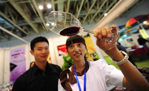 9月26日,參展人員(右)在第十四屆國(guó)際果蔬食品博覽會(huì)上向參觀者介紹葡萄酒產(chǎn)品。新華社發(fā)(初陽(yáng) 攝)