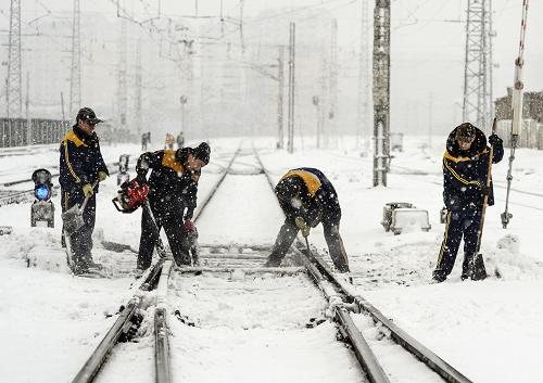 11月21日,鐵路工人在軌道旁清掃積雪。新華社記者 王菲 攝