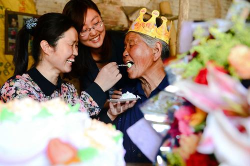國(guó)家電網(wǎng)茌平供電公司的“善小”志愿者在給77歲的貧困母親張成蘭過(guò)母親節(jié)(5月12日攝)。 新華社記者 郭緒雷 攝