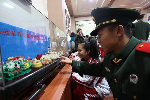 12月6日,遼寧營(yíng)口邊防檢查站官兵與駐地學(xué)生在陳氏面塑館參觀面塑作品。