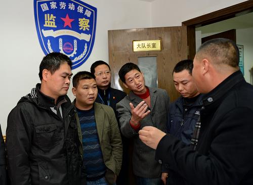 1月14日,來自江西省興國縣高興鎮(zhèn)的農(nóng)民工張森(右三)在福州市鼓樓區(qū)勞動保障監(jiān)察大隊與業(yè)主單位確認(rèn)欠薪數(shù)額。新華社記者 張國俊 攝
