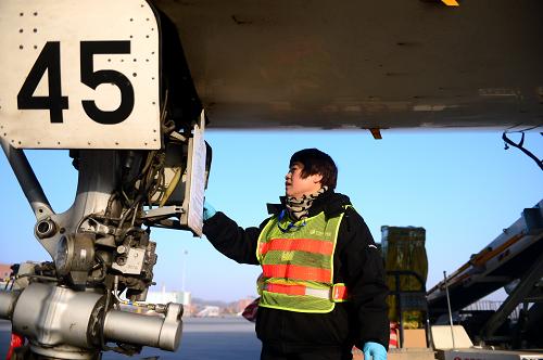 1月15日,李木麗在蘭州中川機場檢查一架飛機的機械設備。新華社記者 張錳 攝