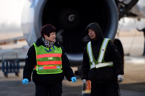 1月15日,在蘭州中川機場,李木麗(左)和同事對飛機狀況進行交流。新華社記者 張錳 攝