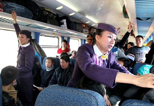 1月16日,毛靜、毛雯姐妹倆在列車上為旅客整理行李和衣帽。新華社記者 陳飛 攝
