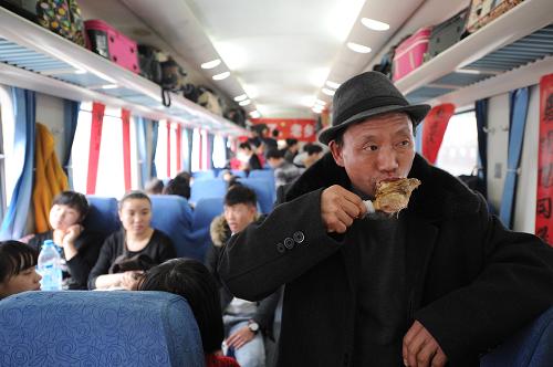 1月16日,一名旅客在上海開(kāi)往貴陽(yáng)的K111次列車(chē)上吃雞腿。新華社記者 劉續(xù) 攝