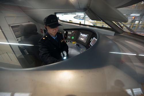 1月16日,重慶車輛段動(dòng)車機(jī)械師黃勇在動(dòng)車組的駕駛室內(nèi)用錄像電筒對(duì)各種動(dòng)車控制設(shè)備進(jìn)行拍攝和安全檢查。新華社記者 劉潺 攝