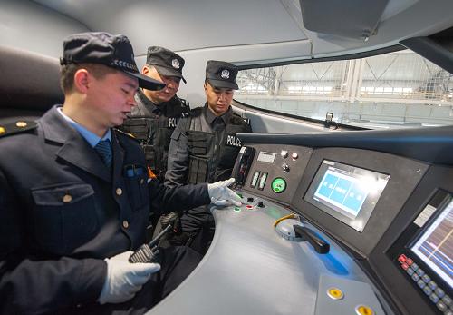 1月16日,重慶鐵路公安處特警支隊(duì)的兩名特警隊(duì)員(右、中)在動(dòng)車駕駛室內(nèi)接受重慶車輛段重慶北動(dòng)車所動(dòng)車機(jī)械師關(guān)于動(dòng)車緊急控制的培訓(xùn)。新華社記者 劉潺 攝