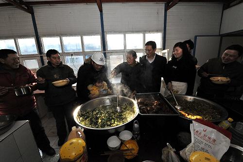 1月28日,從四川來北京與爸爸團聚的曾佳樂小朋友(黃衣)在工地食堂打飯。當日,中鐵一局北京地鐵郭公莊車輛段項目部組織人員將魚肉、干果等年貨和慰問品發(fā)放給春節(jié)期間堅守工地的農(nóng)民工。為了保證北京地鐵9號線按時開通,來自四川、河南、湖北等地的部分農(nóng)民工放棄回家與親人團聚的機會,堅持在工地上施工。新華社記者 何俊昌 攝
