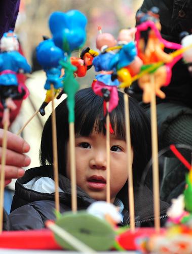2月5日,一位小朋友在挑選面人。當日,由武漢市群眾藝術館聯(lián)合社區(qū)舉辦的新春廟會開市,逛廟會的市民不僅可以欣賞到糖畫、風箏等傳統(tǒng)工藝品制作,還可以參加各種游藝,為春節(jié)增添樂趣。新華社記者 程敏 攝