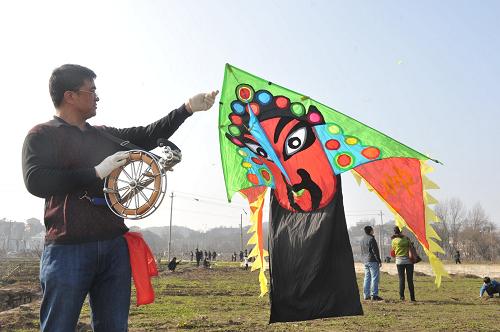 2月5日,一名市民準(zhǔn)備放飛臉譜形狀的風(fēng)箏。當(dāng)日是大年初三。在貴陽(yáng)市風(fēng)景區(qū)花溪河畔,放風(fēng)箏的市民絡(luò)繹不絕。由于“風(fēng)”字與“豐”字諧音,新年放風(fēng)箏,有“豐衣足食”之寓意。新華社記者 歐東衢 攝