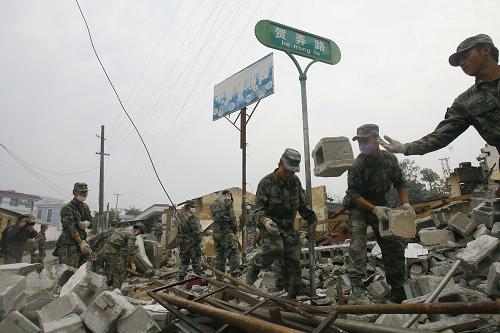 3月12日,救援部隊官兵幫助當(dāng)?shù)鼐用袂謇韽U墟,恢復(fù)生產(chǎn)。新華社發(fā)