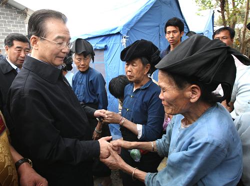 3月18日至19日,中共中央政治局常委、國務(wù)院總理溫家寶來到云南省德宏傣族景頗族自治州盈江縣地震災(zāi)區(qū),指導(dǎo)抗震救災(zāi)和災(zāi)后重建工作,看望慰問受災(zāi)的各族群眾。 這是3月18日,溫家寶在盈江縣弄璋鎮(zhèn)賀哈村看望受災(zāi)群眾。新華社記者 姚大偉 攝