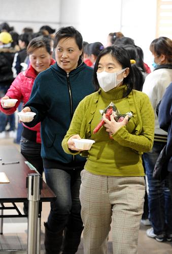 3月19日,在日本新潟市產(chǎn)業(yè)振興中心的臨時安置點,中國留學生、研修生們領(lǐng)取免費的湯和方便食品。新華社記者 宋振平 攝