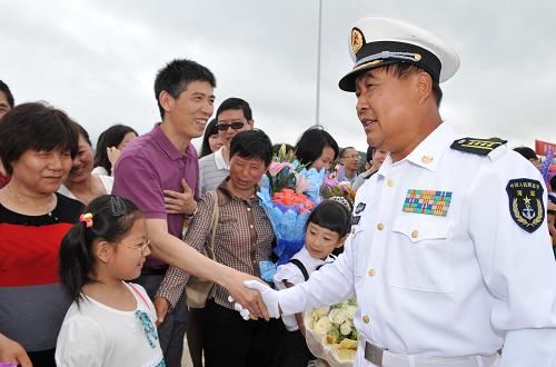 5月9日,海軍第七批護(hù)航編隊(duì)政委李建軍(右)代表編隊(duì)向護(hù)航官兵親屬表示敬意。新華社記者 范軍威 攝
