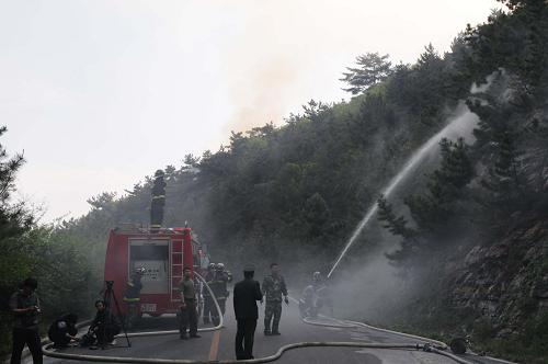5月16日,大連市內(nèi)森林動(dòng)物園西側(cè)的一個(gè)山體發(fā)生山火,消防人員正在現(xiàn)場(chǎng)全力撲救。這是大連市近三天內(nèi)發(fā)生的第三起山火事故。 新華社記者 蔡擁軍 攝