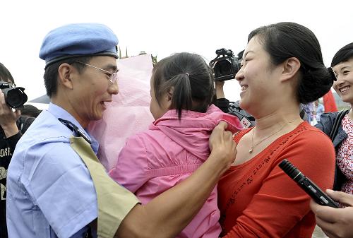 5月20日,抵達濟南的維和警員與家屬重逢。當(dāng)日,我國第十五支赴東帝汶維和警隊的24名隊員圓滿完成為期一年的聯(lián)合國維和任務(wù),乘坐包機抵達濟南遙墻機場,全體隊員均被授予聯(lián)合國和平勛章。這支警隊由山東省公安機關(guān)組建,于去年5月奔赴東帝汶執(zhí)行聯(lián)合國維和任務(wù)。新華社發(fā)(陳進 攝)