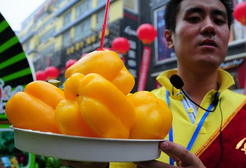 7月2日,在甘肅“高原夏菜”產(chǎn)銷(xiāo)對(duì)接會(huì)上,一名工作人員在展示彩椒。新華社記者 朱國(guó)亮 攝