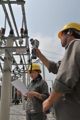 8月19日,變電站操作巡線隊(duì)隊(duì)長(zhǎng)陳峰濤(右)和同事劉家瓊在三峽壩區(qū)的湖北宜昌夷陵區(qū)供電公司110KV黃金卡變電站手持紅外線測(cè)溫儀檢測(cè)設(shè)備溫度。連日來,三峽壩區(qū)持續(xù)高溫。為確保線路設(shè)備安全及轄區(qū)內(nèi)8萬居民正常用電,三峽壩區(qū)湖北宜昌夷陵供電工人在酷暑中奮斗在第一線。新華社記者 馮國(guó)棟 攝