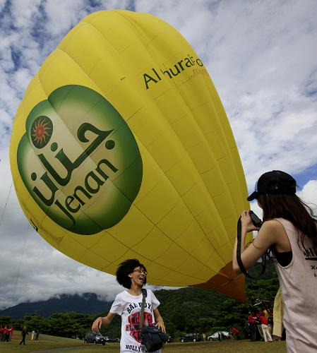 強臺風(fēng)“南瑪都”向臺灣沿??拷?8月27日,在臺灣東南部的臺東縣,游人在被大風(fēng)吹歪的熱氣球旁留影。 當(dāng)日,今年第11號強臺風(fēng)“南瑪都”的外圍已經(jīng)開始影響臺灣東南海域,臺灣東部沿海云層密布,多地出現(xiàn)大風(fēng)及降雨天氣。 新華社記者 任正來 攝