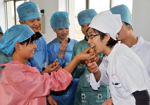 9月8日,在河北邢臺(tái)特殊教育學(xué)校,特教學(xué)生正與老師一起分享親手制作的月餅。 新華社發(fā)(黃濤 攝)