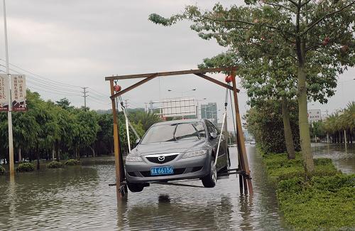 10月3日,南寧沙井大道與公園大地交叉口積水仍未退去,一輛轎車被支架撐起以免被水浸泡。新華社記者 覃星星 攝