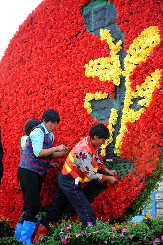 10月14日,環(huán)衛(wèi)工人正在街頭擺放鮮花造型。 隨著第七屆全國城市運動會的日益臨近,江西省南昌市街頭被濃濃的城運會氣氛包圍,城市街頭花團錦簇,洋溢著歡樂和運動的喜慶氛圍,同時低碳出行、綠色環(huán)保等理念使“紅色英雄城 綠色城運會”的口號深入人心。 新華社記者秦晴攝