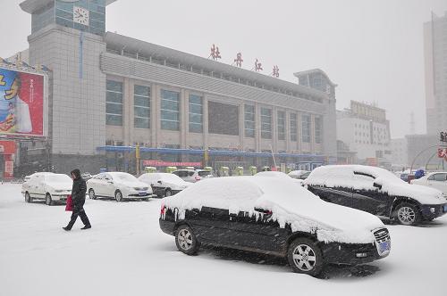 11月23日,牡丹江車站廣場上停放的汽車上覆蓋了厚厚的積雪。 新華社發(fā)(張春祥 攝)