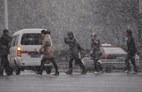 11月23日,在煙臺(tái)市街頭,市民冒著紛紛揚(yáng)揚(yáng)的飛雪出行。新華社發(fā)(初陽(yáng) 攝)