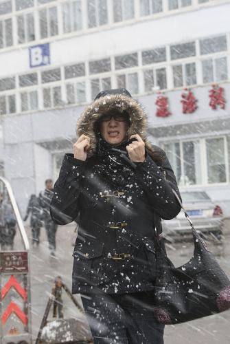 11月23日,在煙臺(tái)市街頭,市民冒雪出行。 新華社發(fā)(初陽(yáng) 攝)