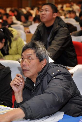 12月24日,兩位選房者正密切關(guān)注選房的進(jìn)展。新華社記者 王定昶 攝
