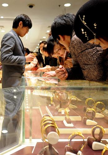 12月24日,顧客在北京菜百公司黃金首飾柜臺(tái)前選購(gòu)。新華社記者 羅曉光 攝