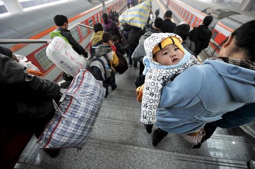1月8日,一位小朋友由母親抱著在寧夏銀川火車站進站上車。新華社記者 彭昭之 攝