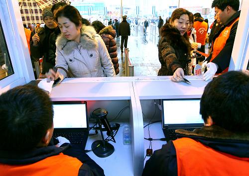 1月8日,旅客在進入上海火車站時驗證驗票通過。新華社記者 陳飛 攝